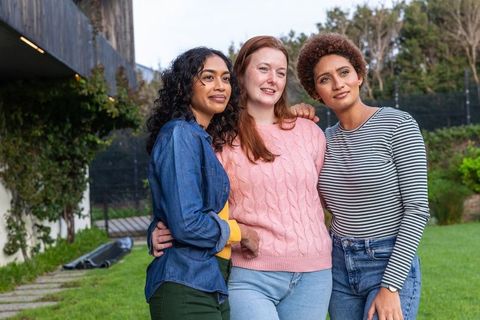 Diverse female friends bonding outdoors in sunny backyard