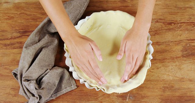 Hands Lining Pie Crust in Baking Dish on Wooden Table - Download Free Stock Images Pikwizard.com