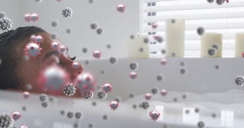 Woman relaxing in bubble bath with candles and virus particle overlay concept