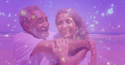 Senior couple embracing seashore, smiling, enjoying serene beach moment with purple glow