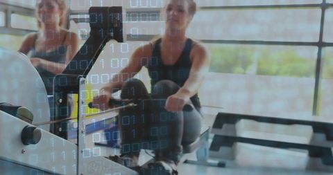 Active Duo Collaborating on Rowing Machines Ready for Fitness Success