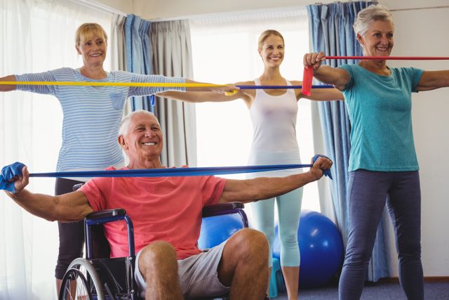 Seniors participating in a fitness class, using resistance bands for stretching exercises. Ideal for promoting senior fitness, healthy aging, group activities, and physical therapy programs. Useful for retirement home advertisements, wellness programs, and health-related articles.