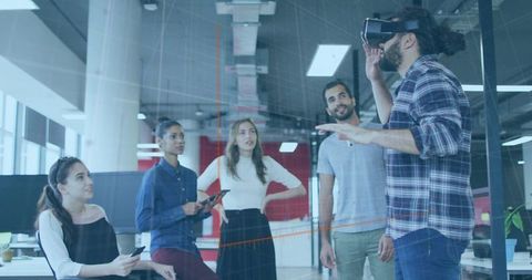 Gesturing Man Using VR Headset in Modern Office During Team Discussion