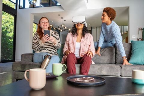 Diverse Friends Enjoying Virtual Reality and Smartphone at Home
