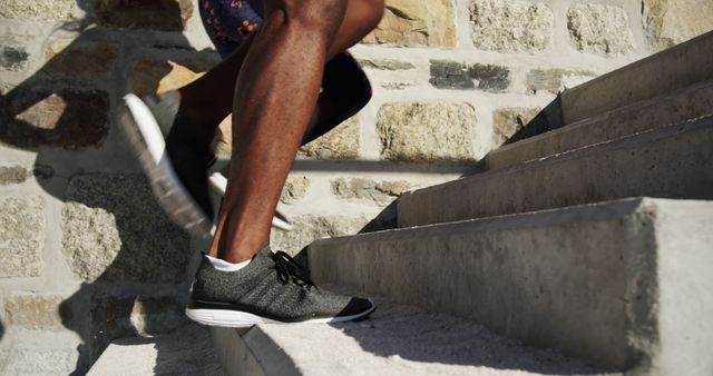 A person is running up stone steps outdoors. Exercise routines often include stair climbing for cardiovascular and strength benefits.