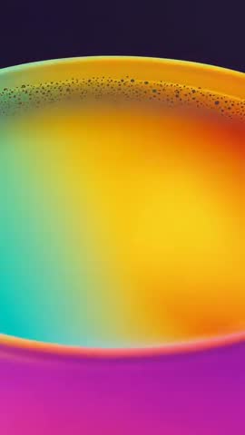 Vertical macro video of nozzle pouring multicolor liquid into shallow cup forming speckled ring