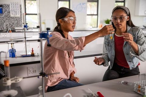 Female Students Collaborating on Science Experiment with Test Tube