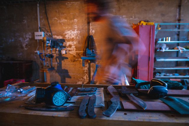 Blurred motion of male worker walking by workbench in forging industry. unaltered, forging, metalwork and manufacturing industry.