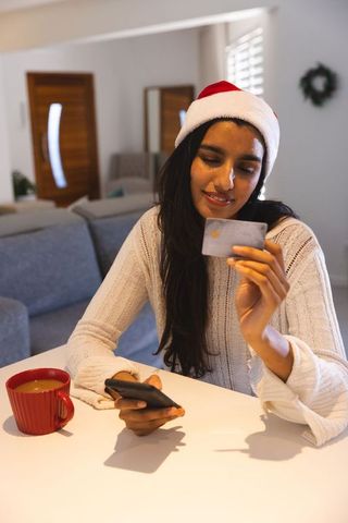 Woman using mobile and credit card during holiday shopping