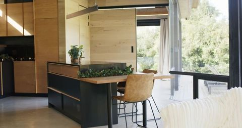 Modern scandinavian kitchen island with integrated planter, tan leather stools and sliding glass doo