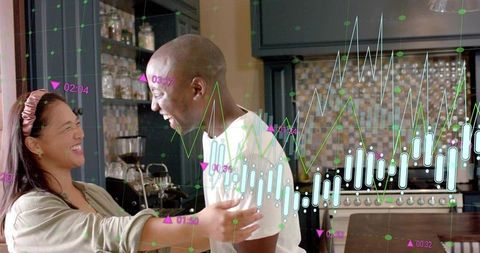 Black man and asian woman embracing and laughing in cozy kitchen with data overlay