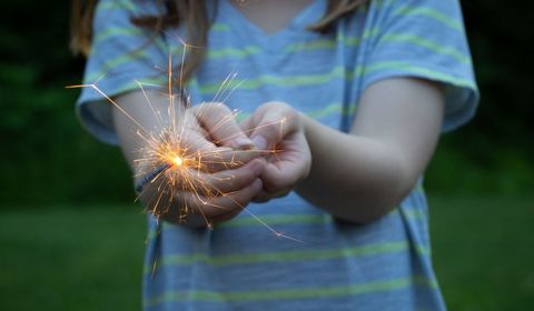 Child holding sparkler creates magical light moments