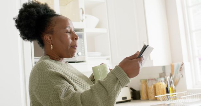 Senior Woman Smiling Holding Credit Cards and Coffee Mug in Kitchen - Download Free Stock Images Pikwizard.com