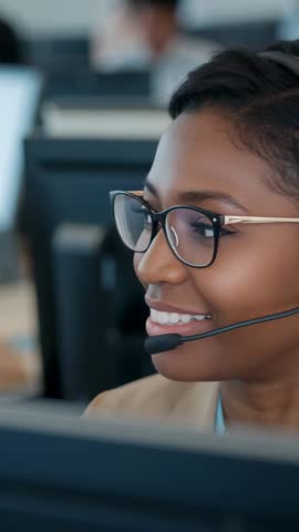 Vertical corporate video: Smiling customer support agent with headset and glasses at desk
