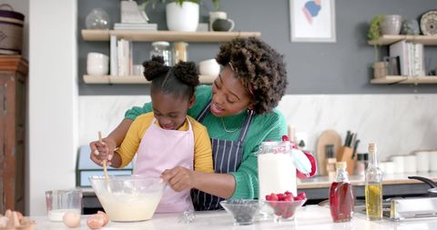 African American Mother and Daughter Bonding While Baking at Home