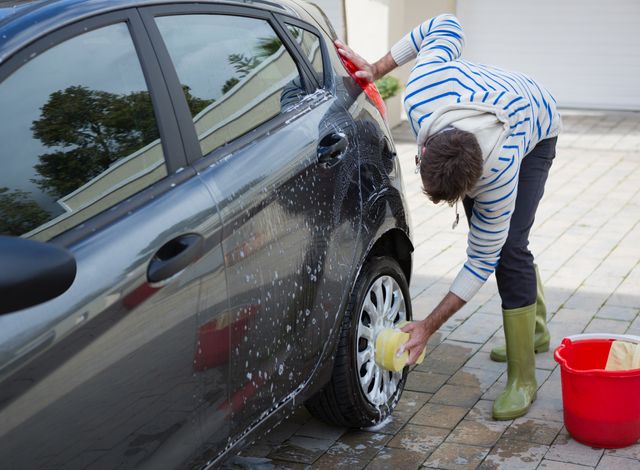 Auto service staff washing a car tyre with sponge - Download Free Stock Photos Pikwizard.com