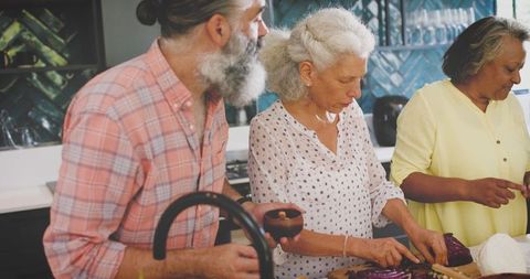 Senior Friends Enjoying Meal Preparation Together in Kitchen