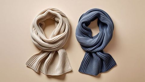 Elegant display of knitted lovers scarves on beige surface for fashion concept