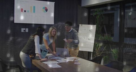 Diverse Team Collaborating Over Data in Conference Room With Digital Overlay