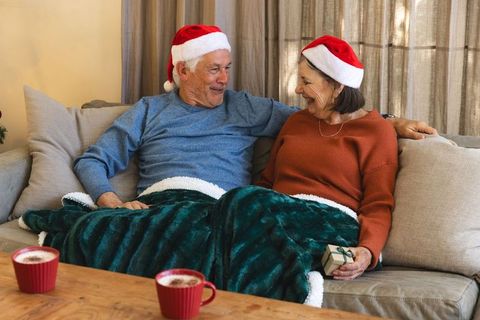 Senior couple enjoying christmas with hot cocoa and gift