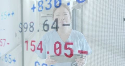 Korean nurse reviewing tablet with digital health data overlay in hospital corridor