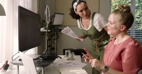 Diverse Female Coworkers Collaborating in Home Office with Charts