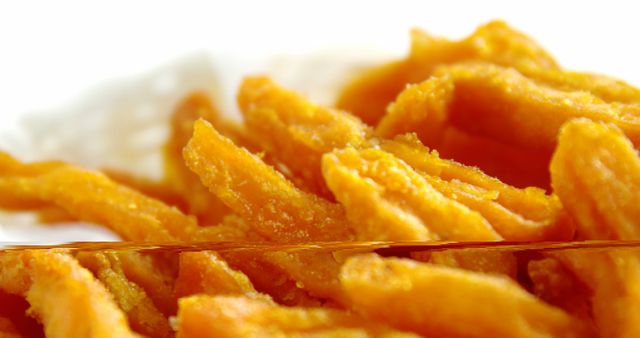 Close-up view of golden, crispy fried potato sticks, perfect for fast food advertisements, menus, or food-related blogs. The rich golden color and crunchy texture convey a delicious and tempting snack option.