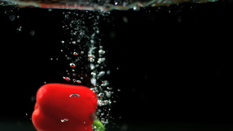 Red Bell Pepper Splashing in Water with Bubbles