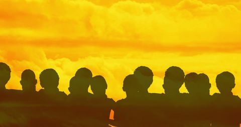 Silhouetted figures against golden clouds