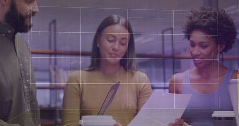 Professional Team Collaborating on Documents at Modern Workspace