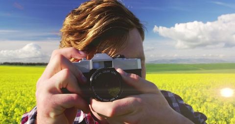 Young Man Capturing Nature in Vast Flower Field - Download Free Stock Images Pikwizard.com