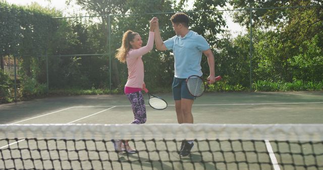 Image of happy biracial couple playing tennis on the court - Download Free Stock Photos Pikwizard.com
