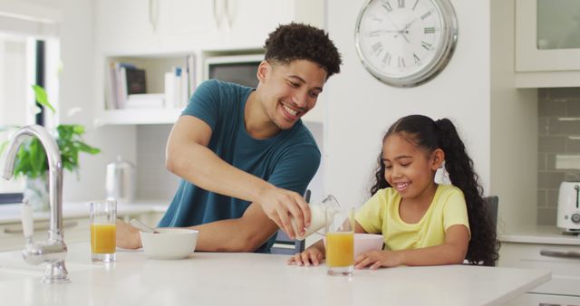 Happy biracial father and daughter eating breakfast together. domestic lifestyle, spending free time at home.