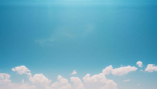 Serene Cumulus Clouds Against Clear Blue Sky
