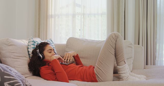 Relaxing Young Woman Listening to Music While Lying on Couch - Download Free Stock Images Pikwizard.com