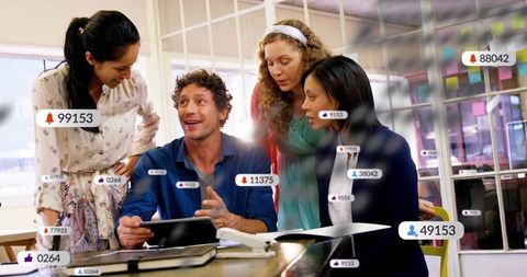 Team collaborating around tablet in modern office showing social engagement metrics