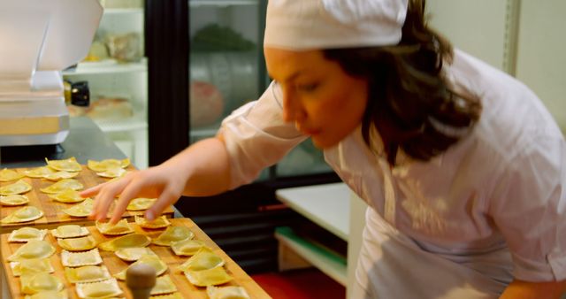 Caucasian female chef preparing dumplings in restaurant kitchen. Cooking, profession, food, work and lifestyle, unaltered.