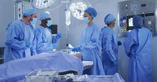 Biracial surgeons wearing protective clothing putting patient to sleep in operating theatre - Download Free Stock Photos Pikwizard.com