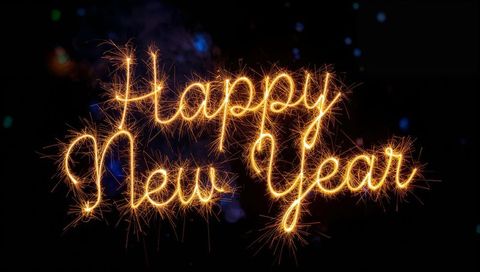 Writing Happy New Year with Sparkler Light Trails and Golden Ember Sparks