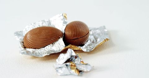 Close-up of Chocolate Eggs in Unwrapped Foil on White Surface