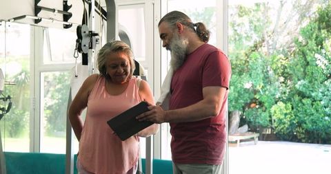 Senior couple discussing fitness plan in home gym setting