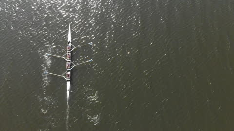 Overhead View of Women's Rowing Team in Motion on River