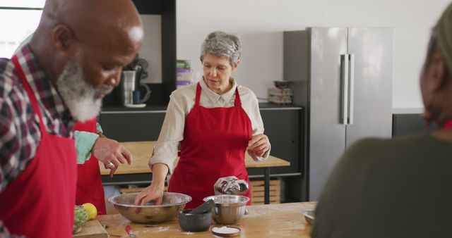 Seniors in Red Aprons Engaging in Group Cooking Activity - Download Free Stock Images Pikwizard.com