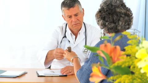Doctor Consulting with Elderly Patient in Medical Office