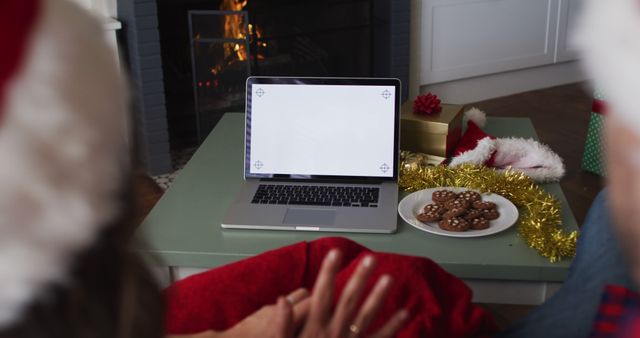 Festive Holiday Scene with Couple Watching Laptop Near Fireplace - Download Free Stock Images Pikwizard.com