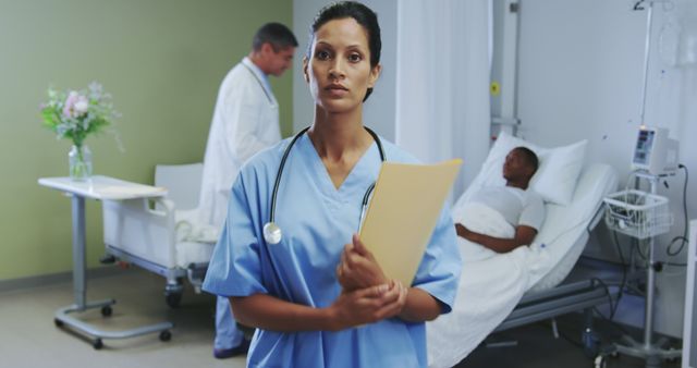 Focused female nurse holding patient file in hospital room - Download Free Stock Images Pikwizard.com