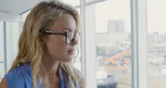 Focused Businesswoman in Glasses Looking Outside Window - Download Free Stock Images Pikwizard.com