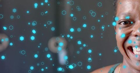 Smiling woman turning to camera with holographic cyan hexagons futuristic studio portrait