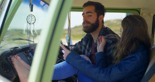 Young couple spending time in a vintage van during their road trip. Man driving while girlfriend sits laid-back with her feet up. The scene captures a carefree and romantic vibe, perfect for themes related to travel, adventure, freedom, and young love. Great for use in lifestyle blogs, travel promotions, and any storytelling involving road trips and outdoor experiences.