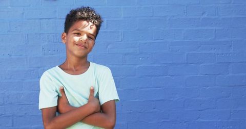 Thoughtful Boy in Blue T-Shirt Against Brick Wall Background